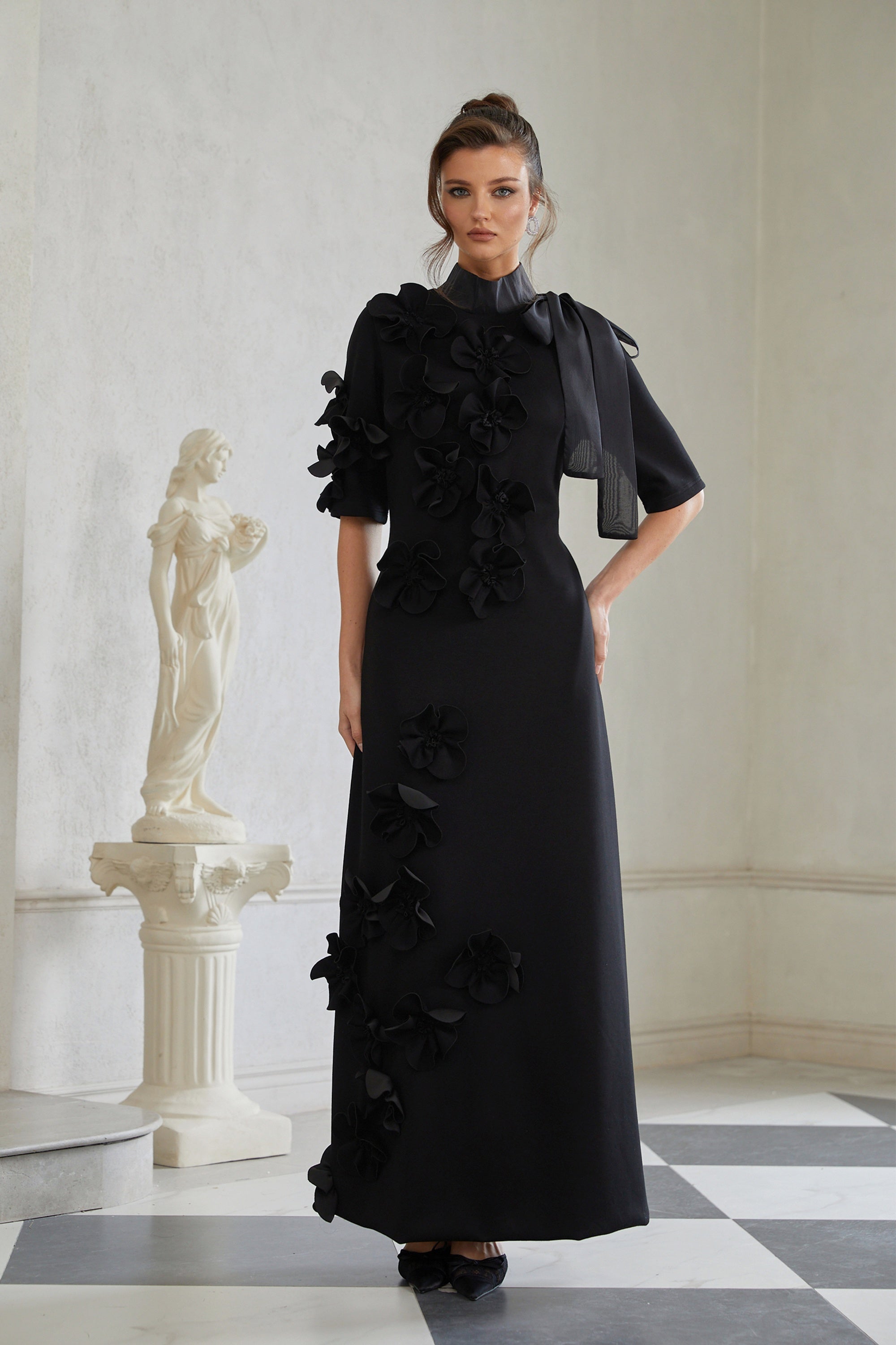 Isidora Schwarzes Maxikleid mit Schleife und Blumenapplikation