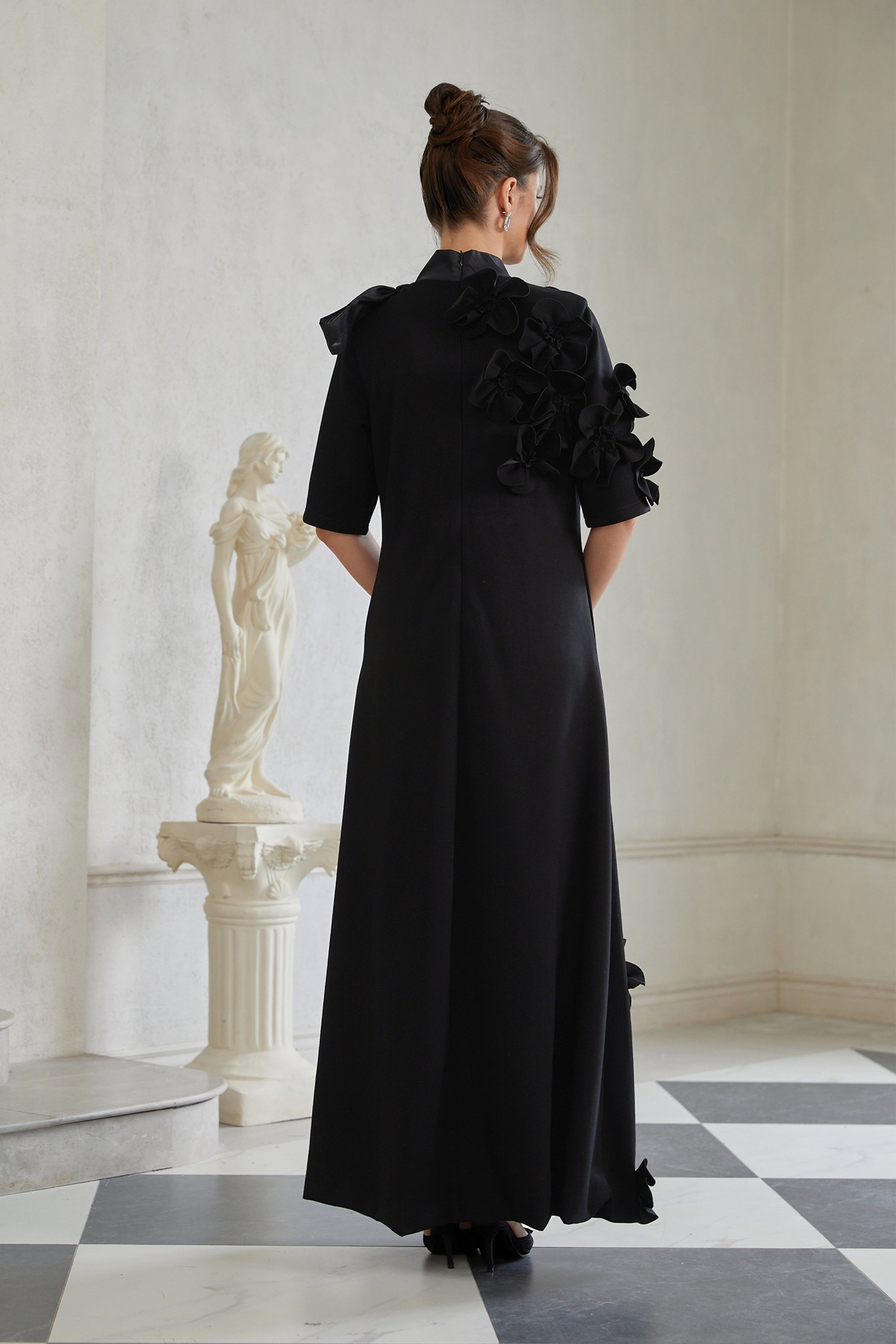 Isidora Schwarzes Maxikleid mit Schleife und Blumenapplikation